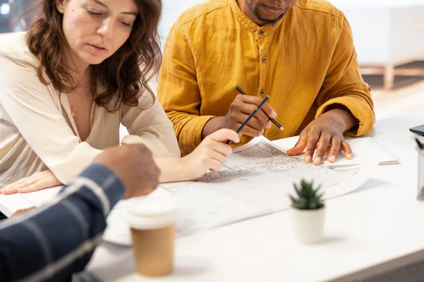 Agentes inmobiliarios se reúnen con un dueño de negocio para revisar todos los términos del contrato.